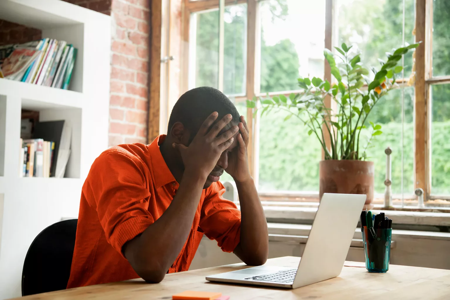 Man sitting frustrated in front of a screen due to the use of outdated spreadsheets